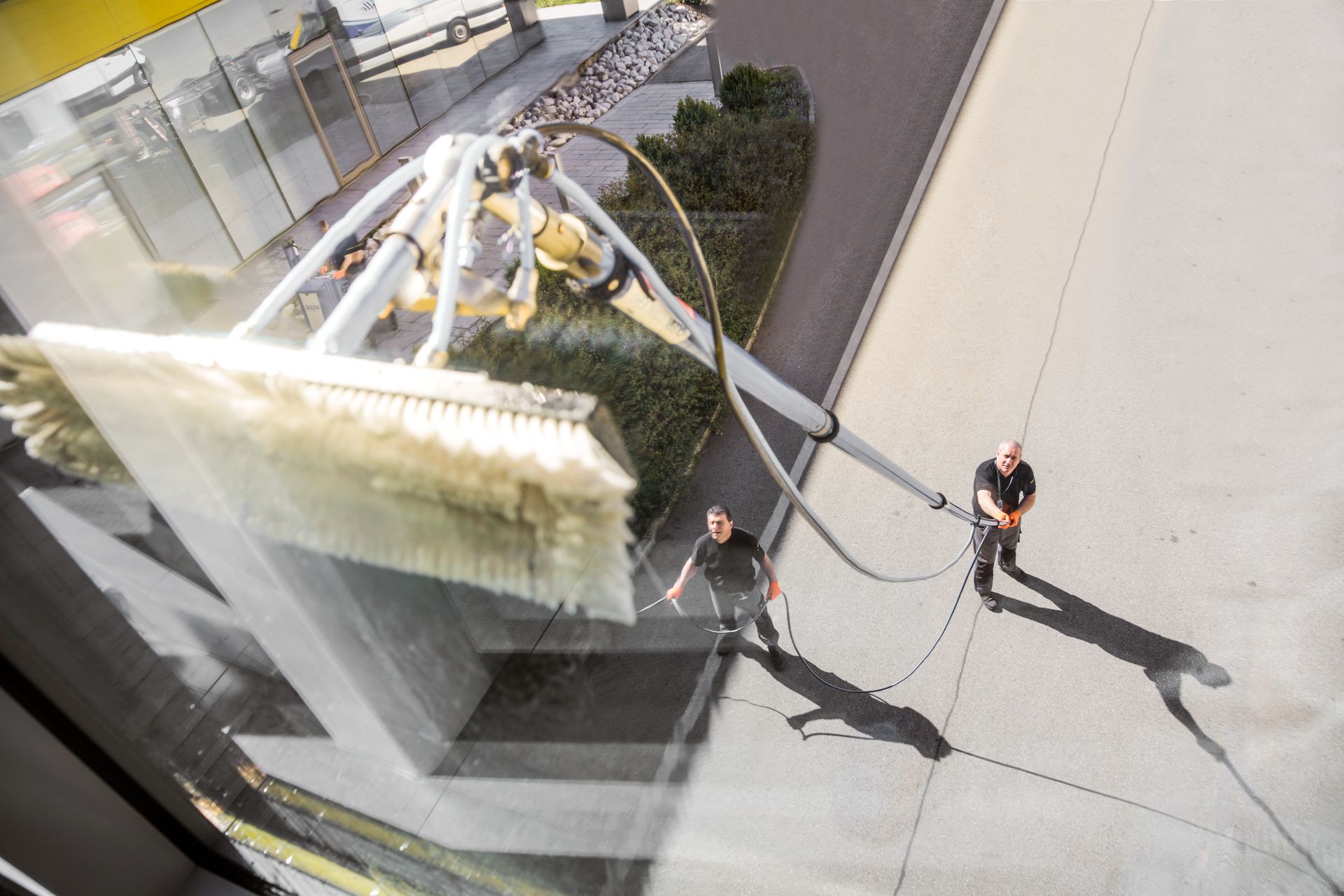 Zwei Fachkräfte beim Hochfensterputz von Innen fotografiert
